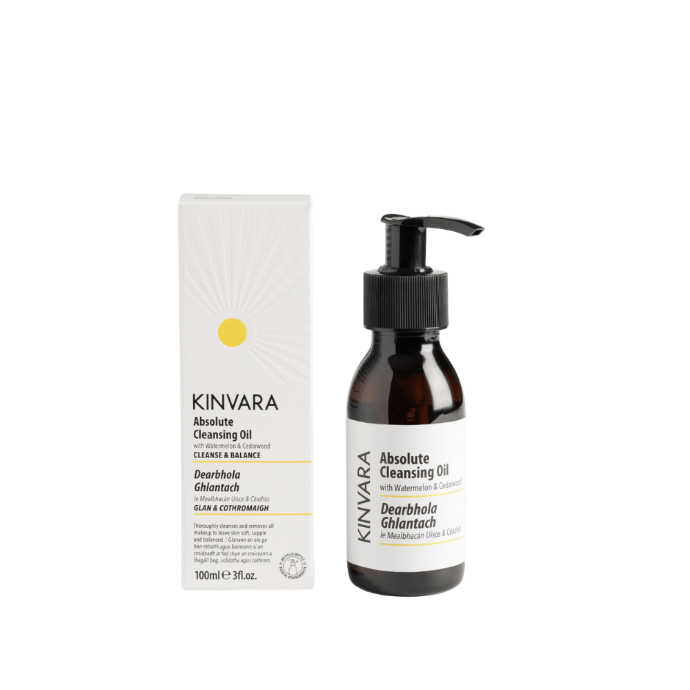 Kinvara Absolute Cleansing Oil shown with its white product box and an amber glass pump bottle on a plain white background.
