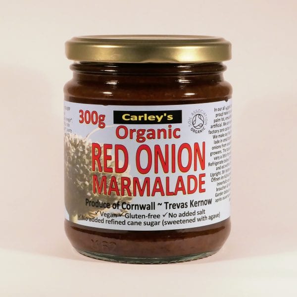 A glass jar of Carley's Organic Red Onion Marmalade with a label indicating it is vegan, gluten-free, no added sugar, and produced in Cornwall.