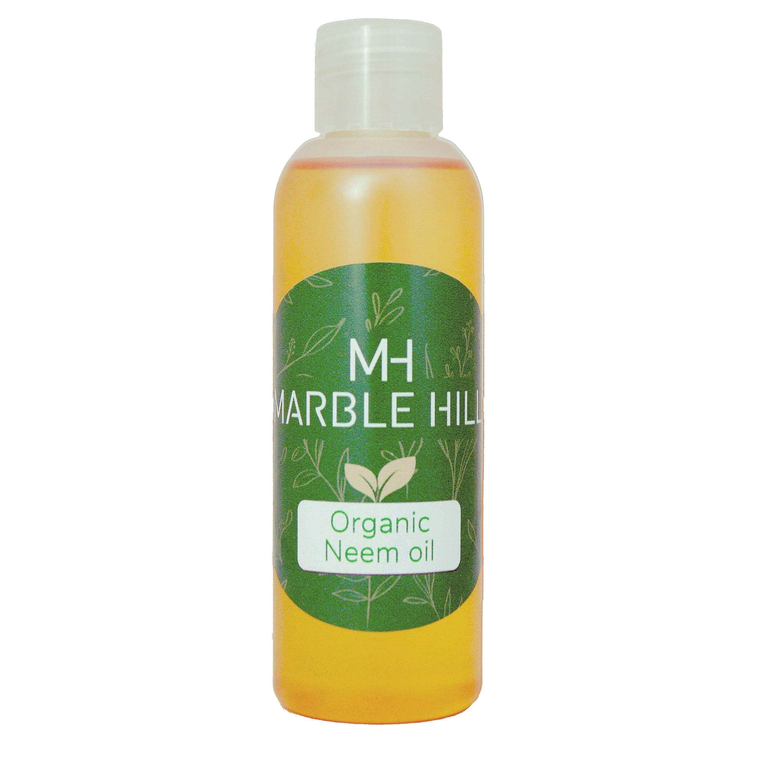 A bottle of Marble Hill Organic Neem Oil with a green label and white cap, filled with yellow-orange liquid, on a white background.