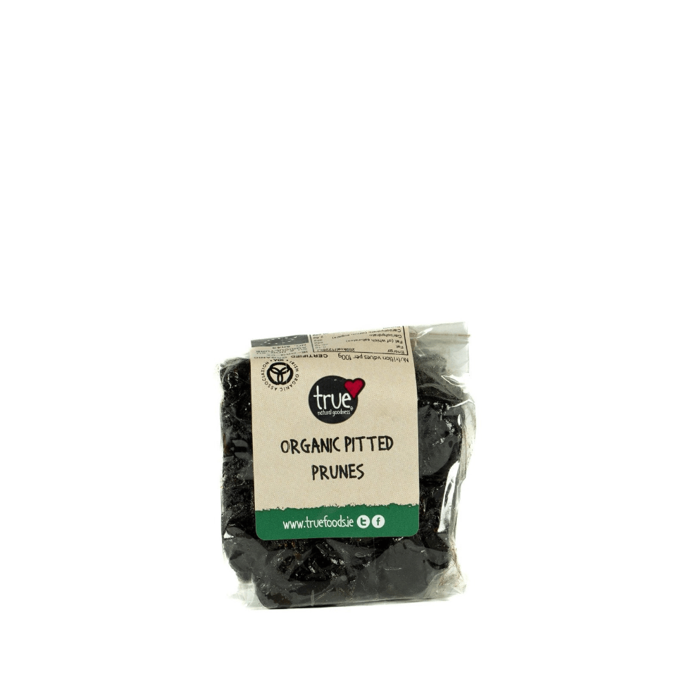 A clear plastic bag of True Organic Pitted Prunes with a beige and green paper label, set against a plain white background.