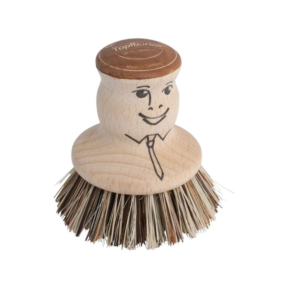 Wooden dish brush with a face design on a white background