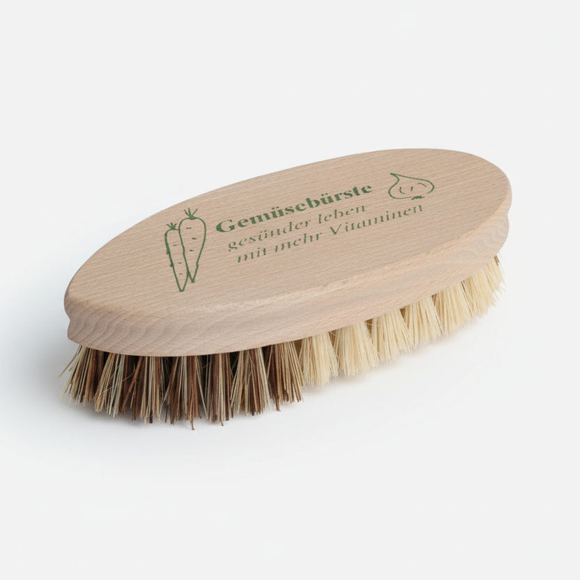 Vegetable cleaning brush with wooden handle and natural bristles on a white background