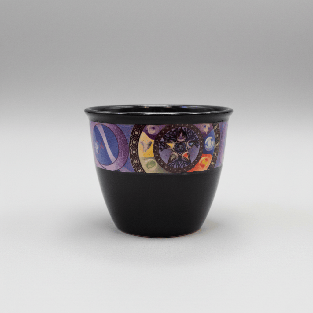 A glossy black ceramic planter or cup with a wide decorative band featuring a purple pentagram, moon phases, and colorful celestial symbols, shown against a plain white background.