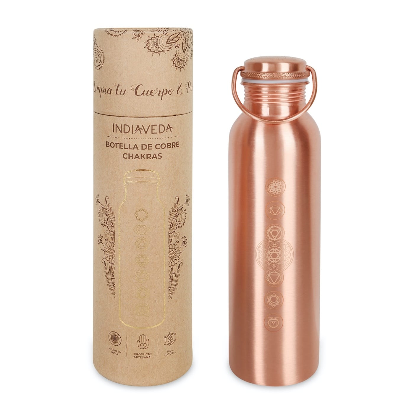 A rose gold chakra water bottle with a matching metal loop lid, standing next to its brown kraft paper packaging tube. The bottle features etched chakra symbols, and the tube is printed with the brand name 'INDIAVEDA' and Spanish text.