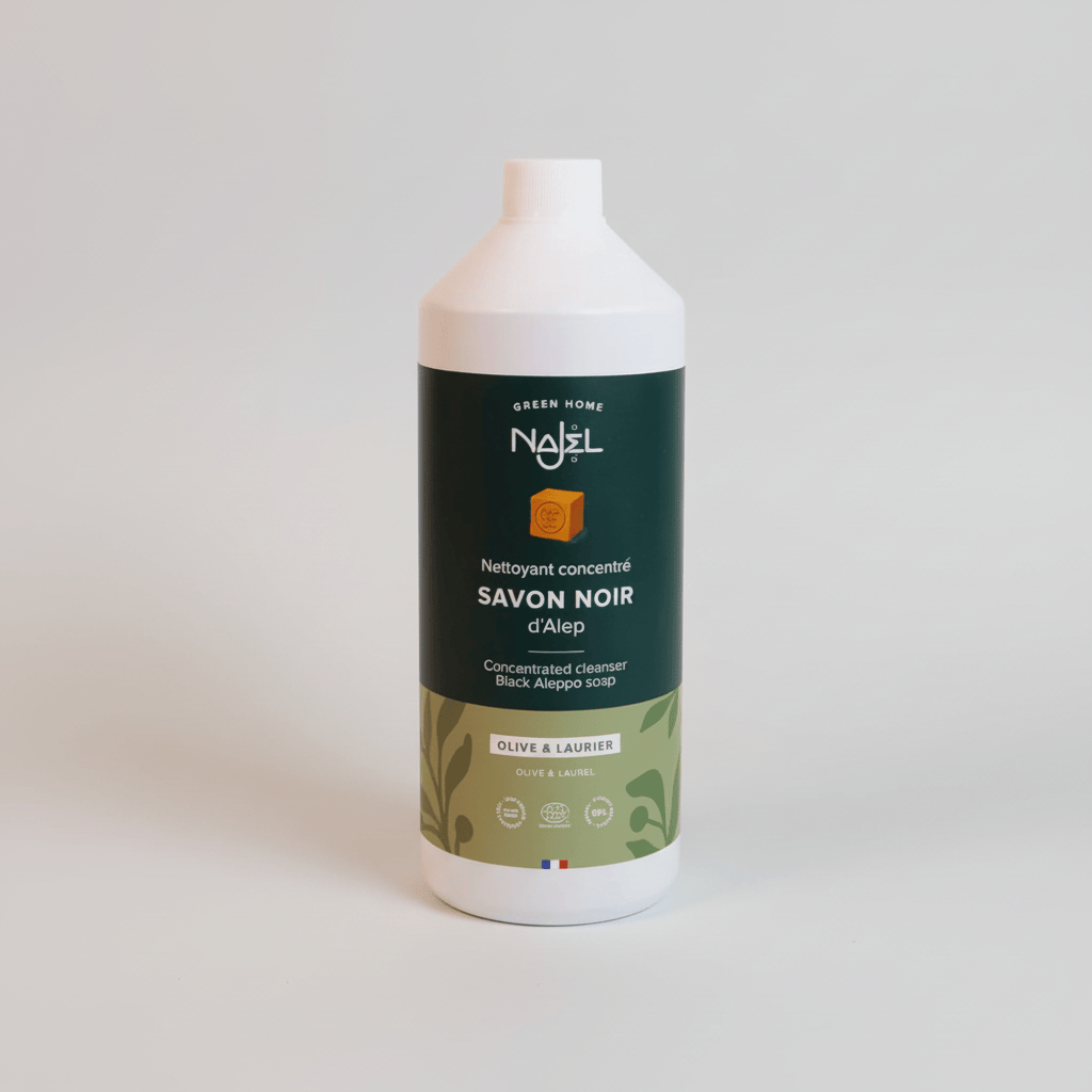 A white plastic bottle of Nadjl Green Home concentrated Black Aleppo soap (Savon Noir) with a dark green and olive-green label, set against a plain off-white background.