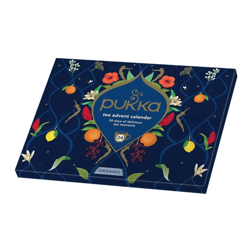 Pukka Tea Advent Calendar box, featuring a dark navy blue background decorated with illustrations of citrus fruits, flowers, and leaves, with the Pukka brand logo in the center.